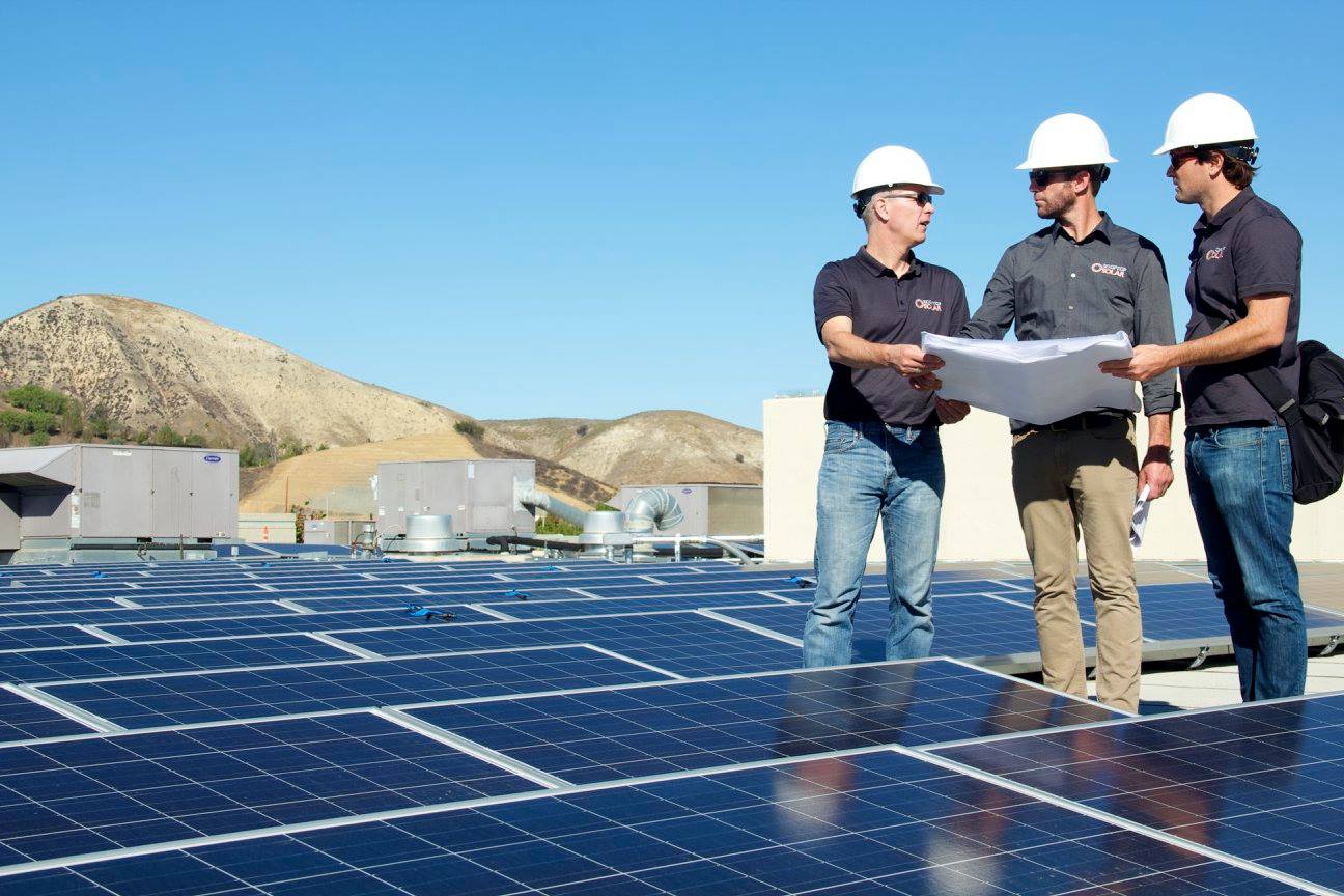 Rooftop Solar employees behind solar panels