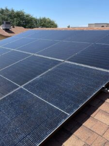 Looking up a row of Hyundai 400-watt solar panels on a shingle roof in Sun City West, AZ, on a sunny day