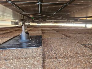 Flashed roof attachment and tidy wiring beneath solar panels on a shingle roof in Sun City West, AZ
